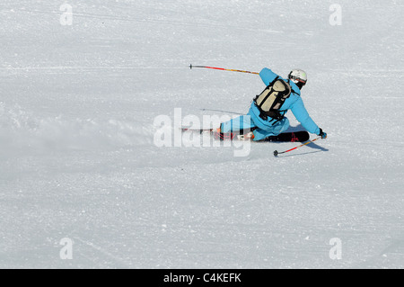 Un skieur se sculpte un tour sur piste dans la station de ski française de Courchevel. Banque D'Images