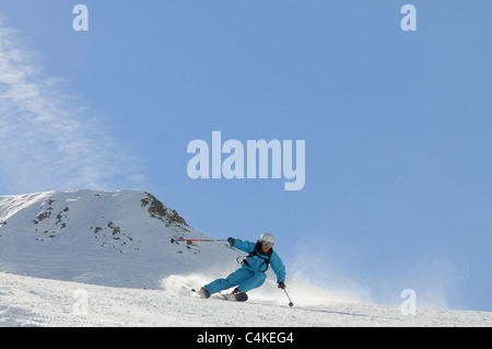 Un skieur se sculpte un tour sur piste dans la station de ski française de Courchevel. Banque D'Images