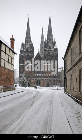 La Cathédrale de Lichfield montrant l'avant et à l'ouest trois spires lors d'une averse de neige d'hiver de la route couverte de neige Fermer Banque D'Images