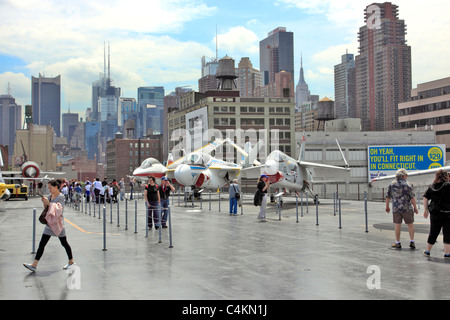 Les touristes sur le pont du porte-avions USS Intrepid Sea Air and Space Museum, Manhattan skyline en retour, New York City Banque D'Images