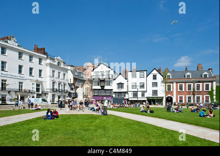 Le livre vert de l'Exeter Cathédrale où il y a de nombreux cafés, bars et restaurants avec les gens se détendre au soleil sur l'herbe. Banque D'Images