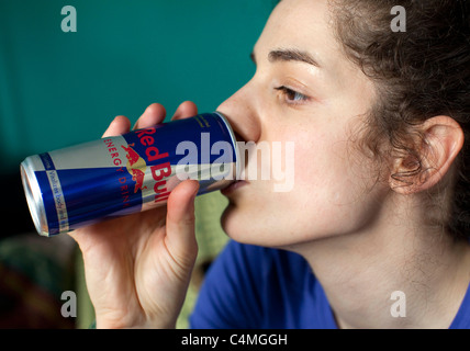 Jeune femme à boire peut de Red Bull energy drink, Londres : MODÈLE libéré Banque D'Images