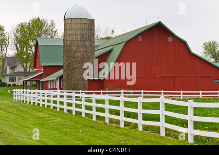 Une étable laitière rouge avec clôture blanche dans la région de Goshen, Indiana, USA. Banque D'Images