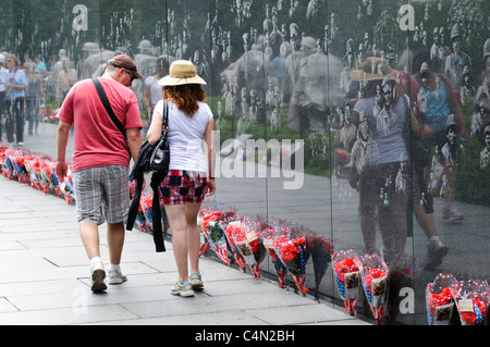 WASHINGTON DC, USA - Des centaines de bouquets de fleurs la ligne reflétant mur de la Korean War Veterans Memorial sur le National Mall à Washington DC. Gravée dans le mur sont des milliers d'images montrant des photos d'Américains qui sont morts dans la guerre. Banque D'Images