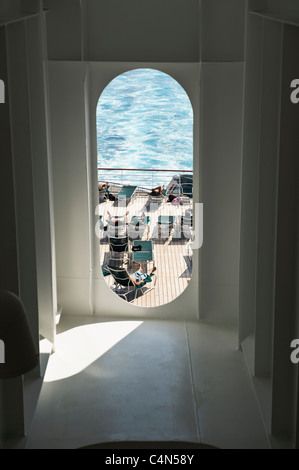 Les passagers à bronzer près de la piscine sur le Queen Mary 2 Lors de traversée transatlantique. Banque D'Images