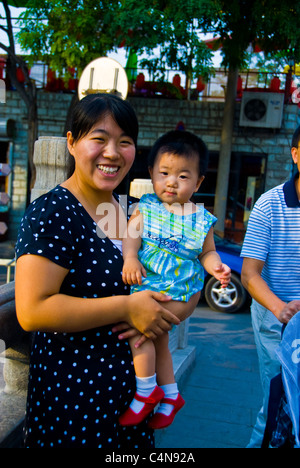 Pékin, Chine, mère chinoise posant avec enfant dans les armes dans la rue, portraits, classe moyenne asie Banque D'Images