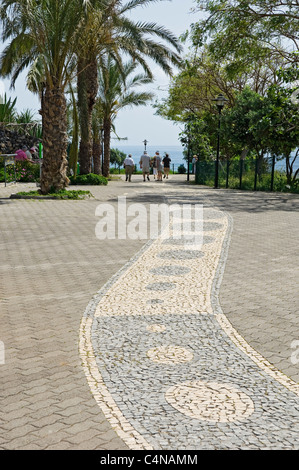 Gens touristes visiteurs marchant le long de la promenade marcher entre le Lido et Praia Formosa Funchal Madère Portugal Europe Banque D'Images