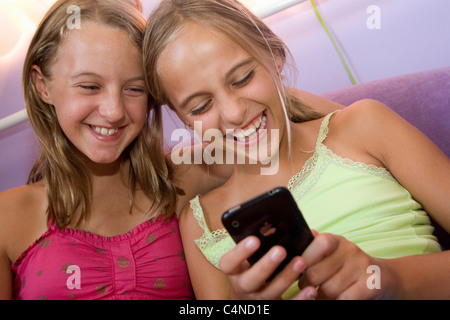 Deux jeunes filles, jouant sur l'iPhone Banque D'Images