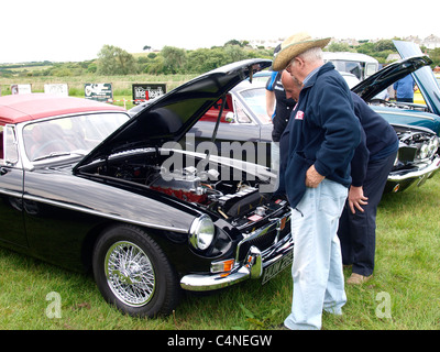 Deux vieillards à la recherche sur le moteur d'un MG, car show Bude, Cornwall, UK Banque D'Images
