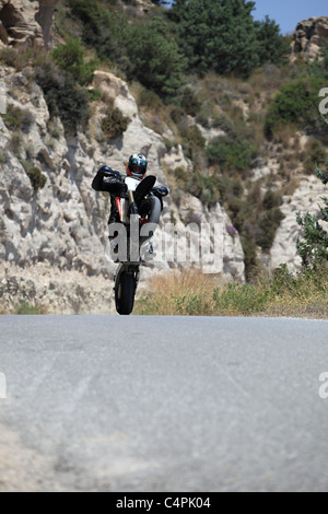 L'homme en faisant un wheelie avec sa moto de course à Kefalos Kos Grèce Banque D'Images