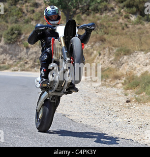 L'homme en faisant un wheelie avec sa moto de course à Kefalos Kos Grèce Banque D'Images