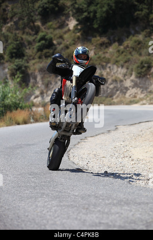 L'homme en faisant un wheelie avec sa moto de course à Kefalos Kos Grèce Banque D'Images