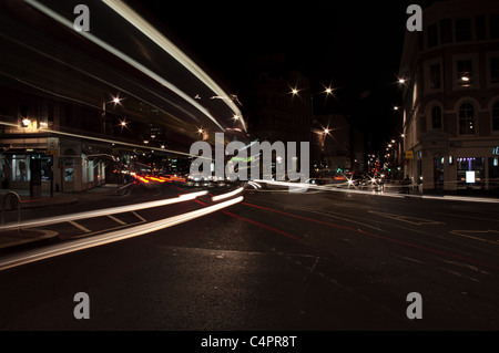 Une scène de nuit dans une ville occupée cinq voies de jonction. Les bus créer des stries claires. Créer des voitures traînées rouges. Attendre que d'autres changements de lumière Banque D'Images