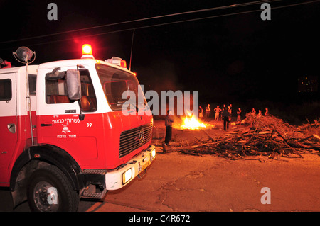 Israël, Haifa, le pompier est à côté d'un grand feu de joie lors de la fête de Lag Baomer Banque D'Images