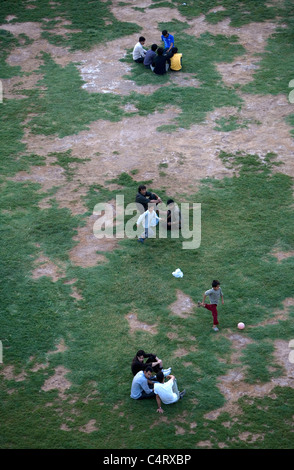 Les gens se détendre et jouer au football en face de complexes d'Amir Chakmak zoroastrienne à Yazd, Iran Banque D'Images