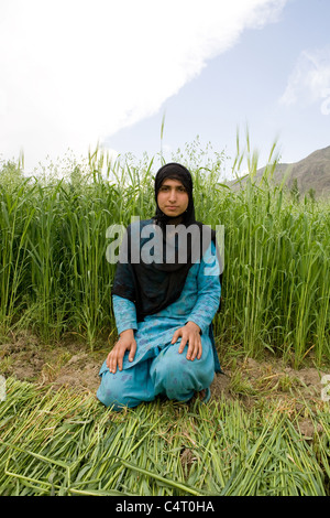 Femme du Cachemire est situé en face de champs d'herbe près de Manasbal Lake, dans l'état de Jammu-et-Cachemire, l'Inde Banque D'Images