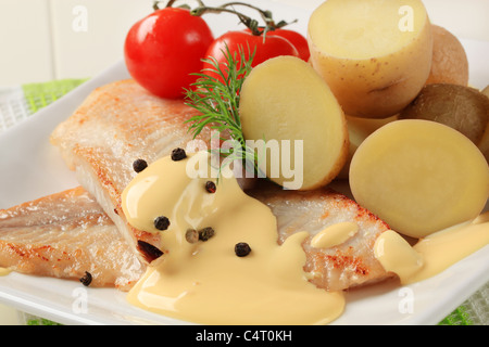 Filets de poisson frit avec des pommes de terre et sauce hollandaise Banque D'Images