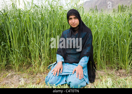 Femme du Cachemire est situé en face de champs d'herbe près de Manasbal Lake, dans l'état de Jammu-et-Cachemire, l'Inde Banque D'Images