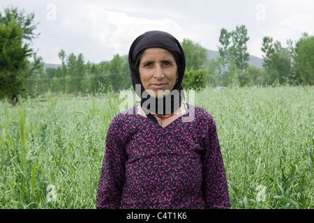 Femme du cachemire dans l'herbe près de champs Manasbal Lake, dans l'état de Jammu-et-Cachemire, l'Inde Banque D'Images