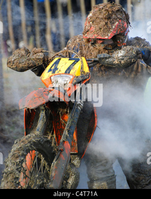 Motor bike rider vélo poussant hors de la boue pendant la course enduro Banque D'Images