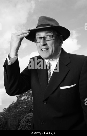 Old fashioned 1940-1950s gentleman portant un chapeau Fedora Trilby ou et des lunettes, B/W. Banque D'Images