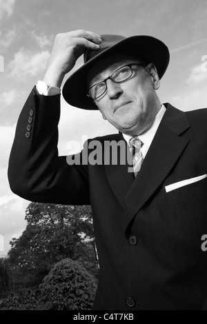 Old fashioned 1940-1950s gentleman portant un chapeau Fedora Trilby ou et des lunettes, B/W. Banque D'Images