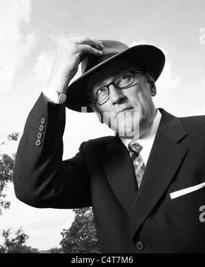 Old fashioned 1940-1950s gentleman portant un chapeau Fedora Trilby ou et des lunettes, B/W. Banque D'Images