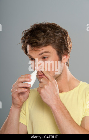 L'homme à l'aide de spray nasal Banque D'Images