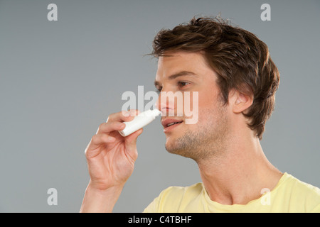 L'homme à l'aide de spray nasal Banque D'Images