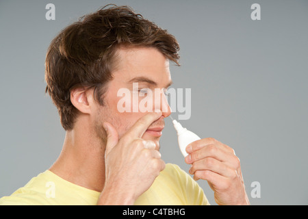 L'homme à l'aide de spray nasal Banque D'Images