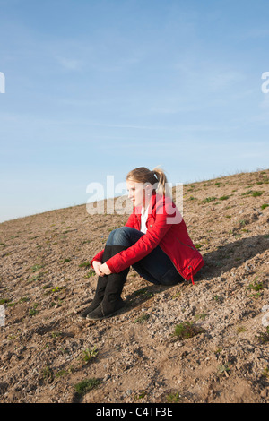 Adolescent assis sur le sol Banque D'Images