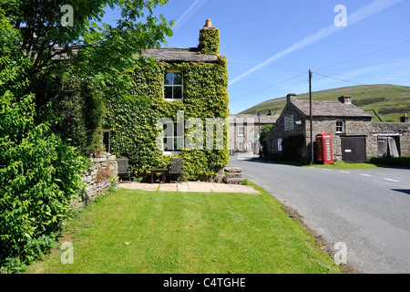 Boîte de téléphone rouge historique dans le village de Thwaite, Swaledale, Yorkshire, Angleterre Banque D'Images