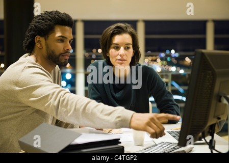 Des collègues qui travaillent sur l'ensemble du projet à l'office de nuit Banque D'Images