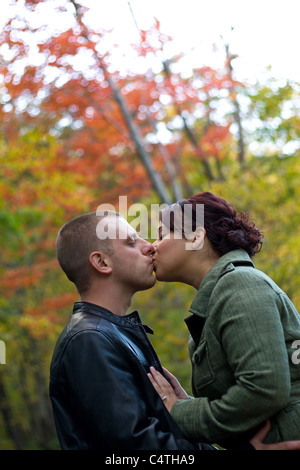 Un jeune couple s'embrasser avec passion en plein air durant l'automne ou l'automne. Banque D'Images