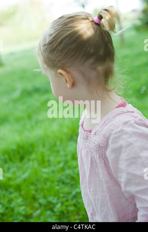 Girl outdoors, looking over shoulder Banque D'Images