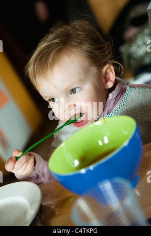 Bébé fille elle-même d'alimentation avec cuillère Banque D'Images