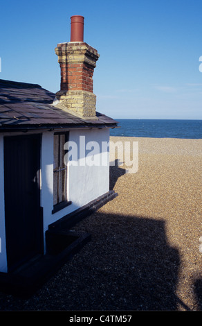 Détail de maison de plain-pied ou lodge avec grand cheminée en brique sur plage de galets avec les ombres et la mer bleue Banque D'Images