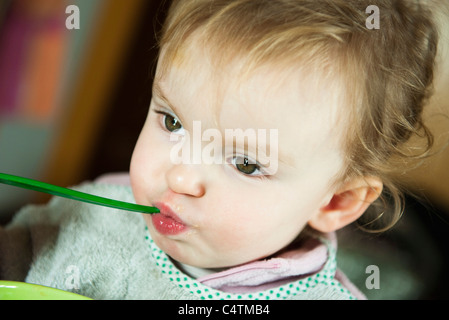 Alimentation bébé fille elle-même, portrait Banque D'Images