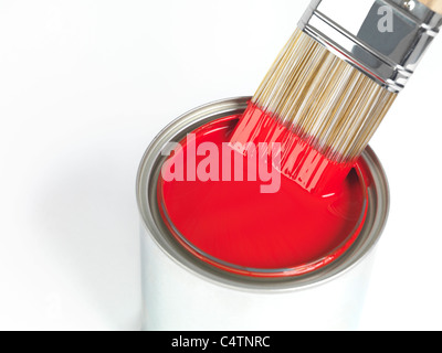 Peinture pinceau trempé dans peut de peinture rouge isolé sur fond blanc Banque D'Images