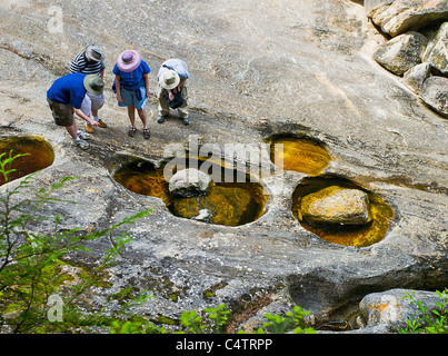 Groupe de personnes, les scientifiques, à près des trous d'eau au sol d'rock Banque D'Images