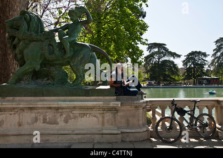 La lecture dans le monument à Alfonso XII, le parc du Retiro, Madrid, Espagne. Banque D'Images