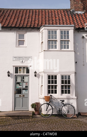 Entrée extérieure du Community & information Center (cottage blanc blanchi à la chaux et carreaux rouges) dans la ville pittoresque de Boroughbridge, Yorkshire, Angleterre, Royaume-Uni. Banque D'Images