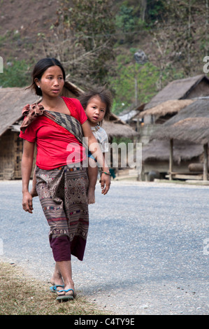 Mather et sa fille marche dans les rues d'un petit village près de Viang Vieng, Laos Banque D'Images