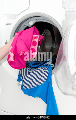 Young Caucasian woman vidage du bras de lavage propre dans des lave-linge, prises à Bristol, Angleterre, Royaume-Uni Banque D'Images