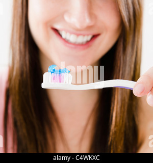 Close-up of smiling young woman holding toothbrush Banque D'Images