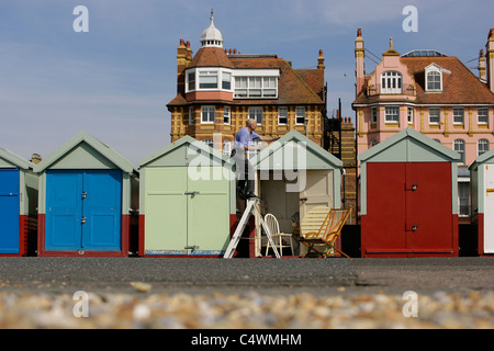 Un homme peint une cabane de plage sur Hove front de mer. Photo par James Boardman. Banque D'Images