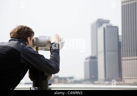 USA,New York City Manhattan skyline,man through telescope Banque D'Images