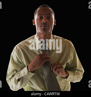 Businessman tying tie Banque D'Images