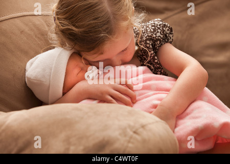 USA, Utah, Léhi, Girl (2-3) embracing baby sister sur canapé Banque D'Images