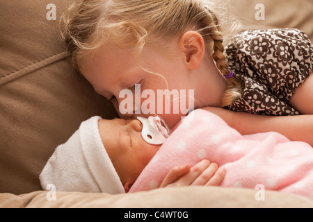 USA, Utah, Léhi, Girl (2-3) embracing baby sister sur canapé Banque D'Images